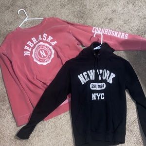 two sweatshirts. one red nebraska crew neck. one black new york city hoodie.
